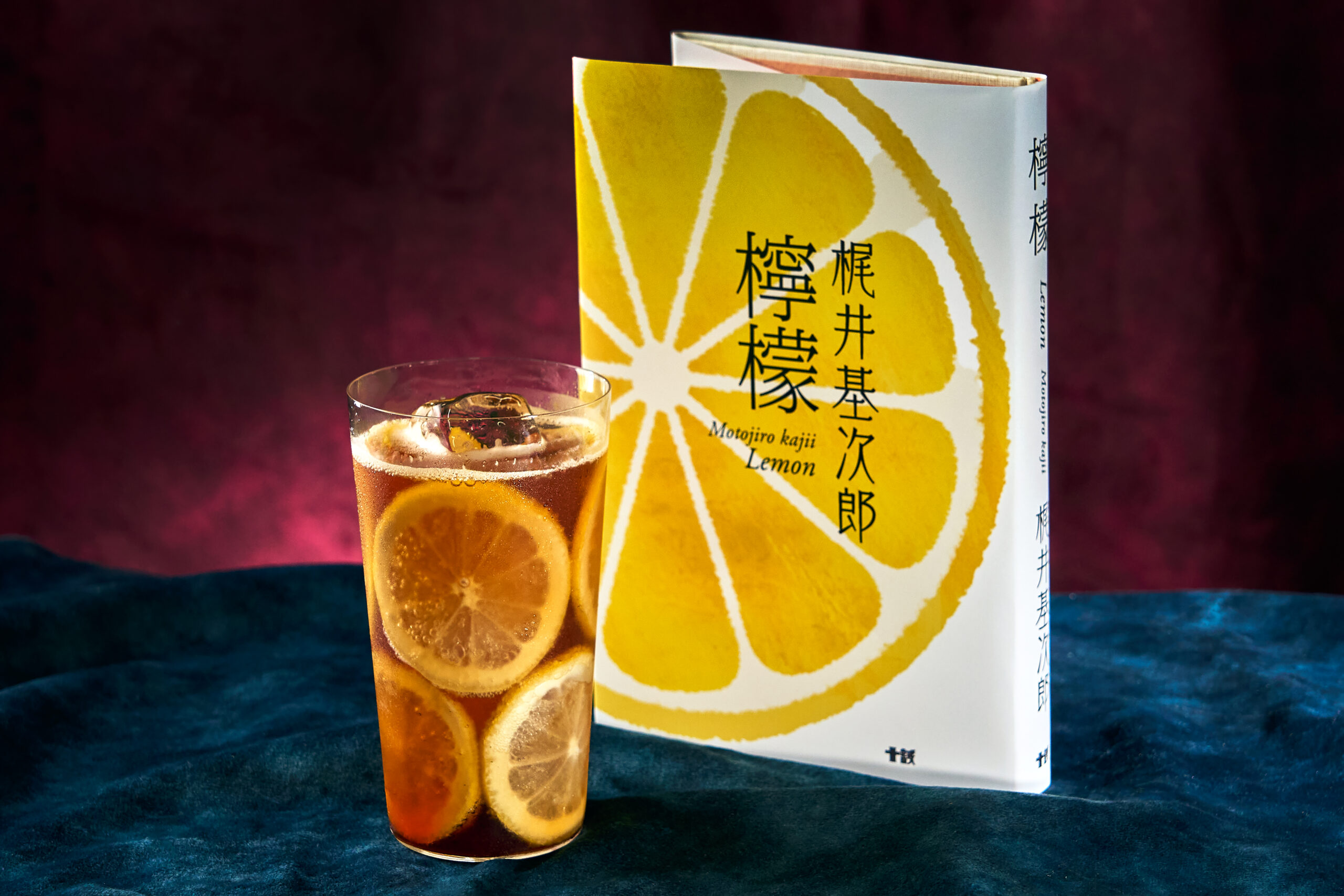 梶井基次郎『檸檬』の本と並ぶ、檸檬スライスをたっぷり浮かべた琥珀色のスパークリングティーモクテル